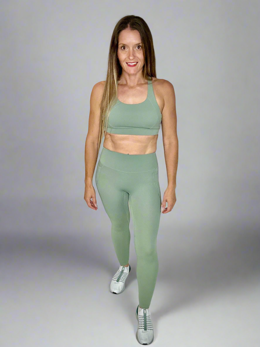 Model wearing Ignite Sportswear Set in moss by Rival Fit Gear.