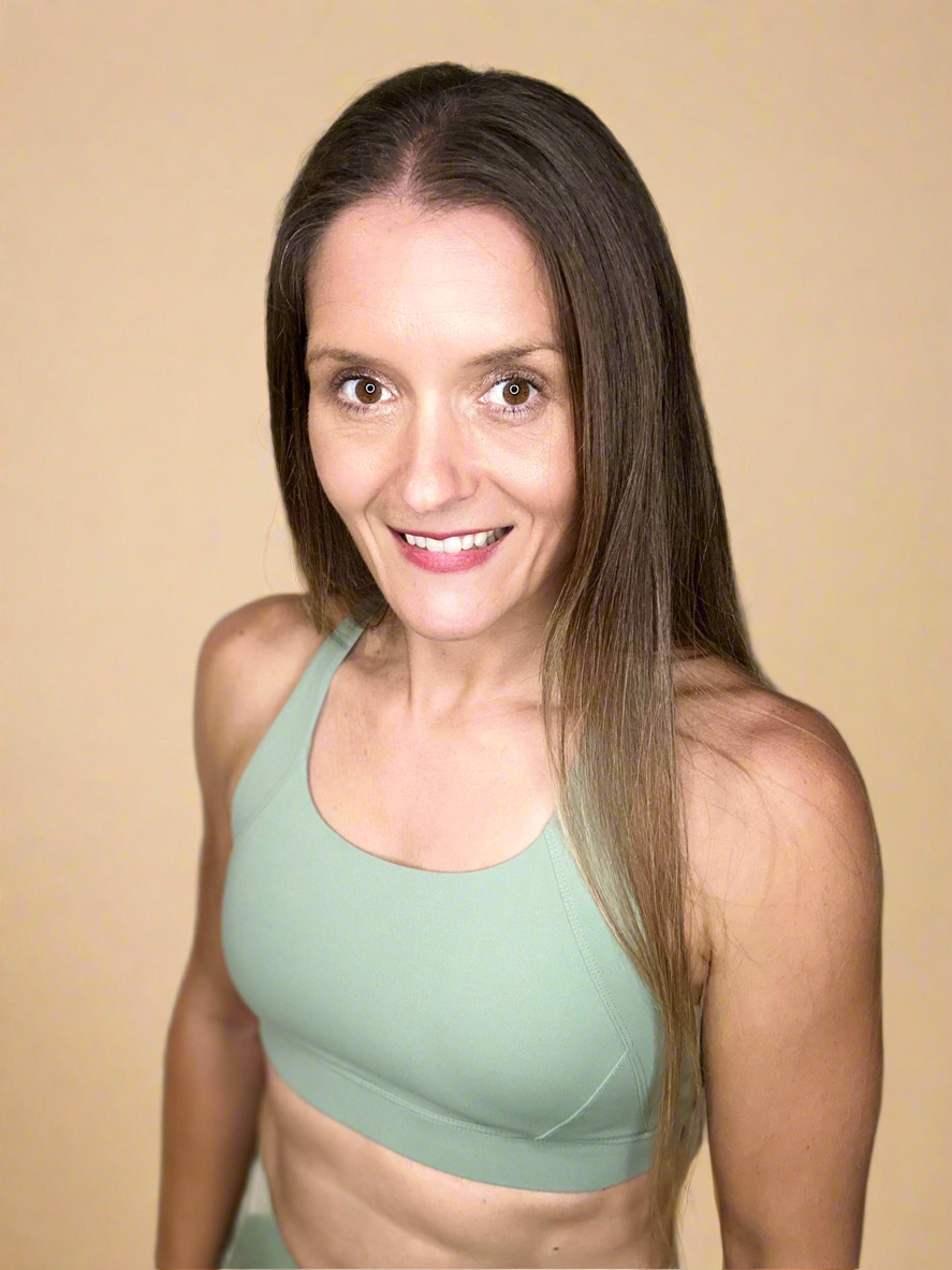 Model wearing Ignite X Bra in Moss detailing front image.