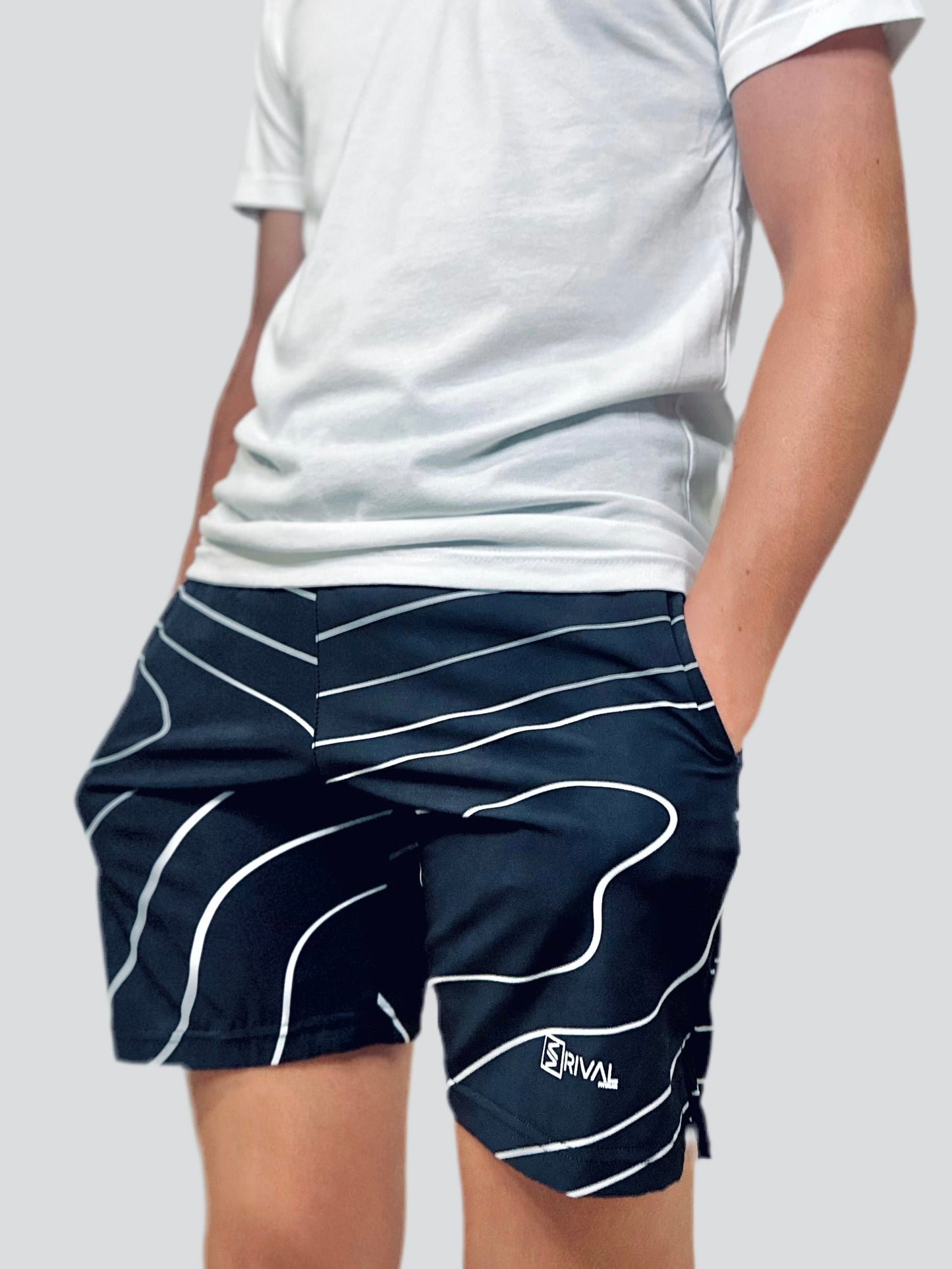 Male model showcasing Tidal Wave Shorts designed by Rival Fit Gear.