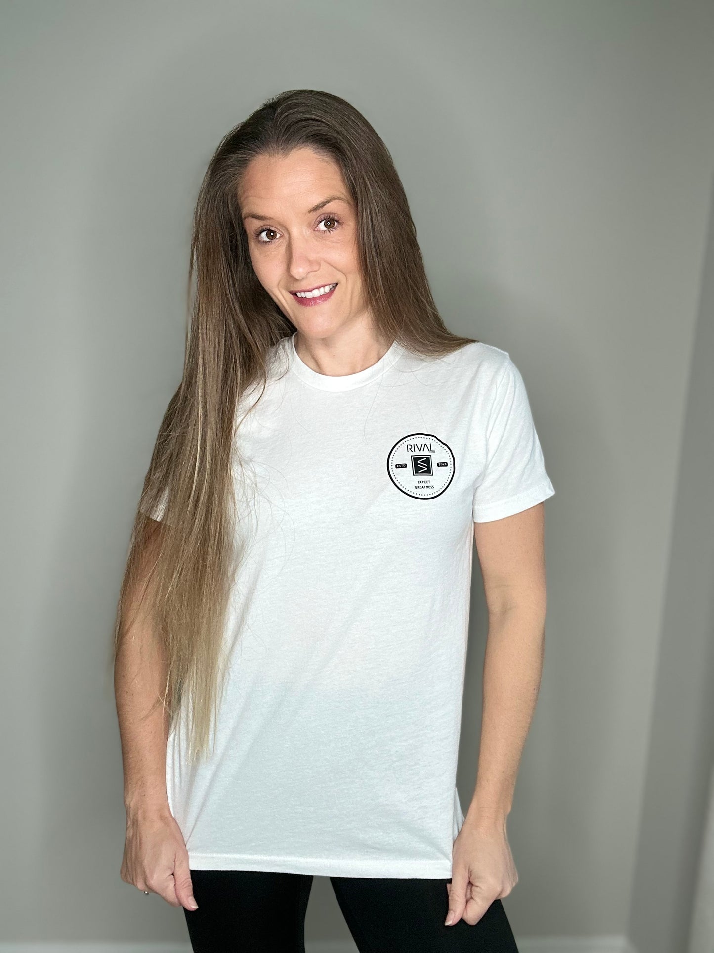 Woman wearing a white t-shirt with a logo on a plain background