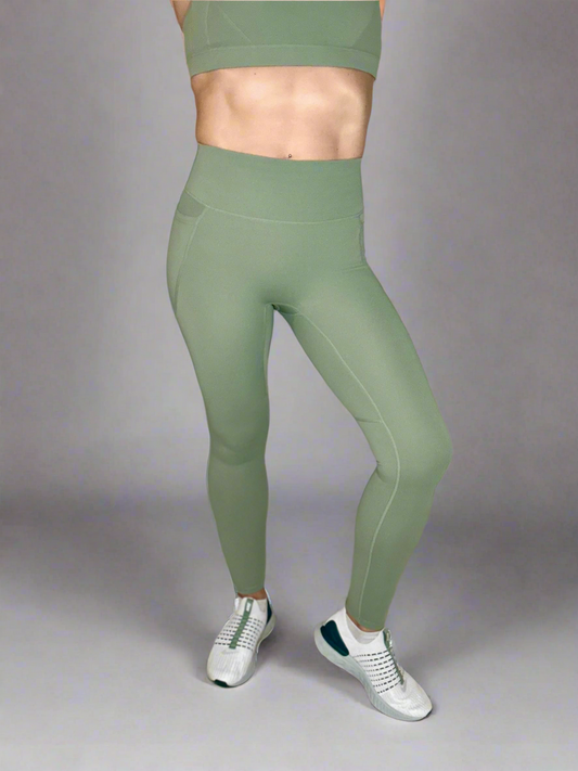 Women modeling Rival Fit Gear Ignite Pocket Leggings in Moss.