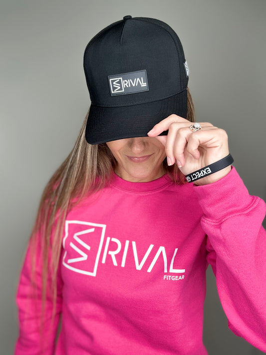 Female model tipping Rival Fit Gear hat and wearing bracelet and sweatshirt.