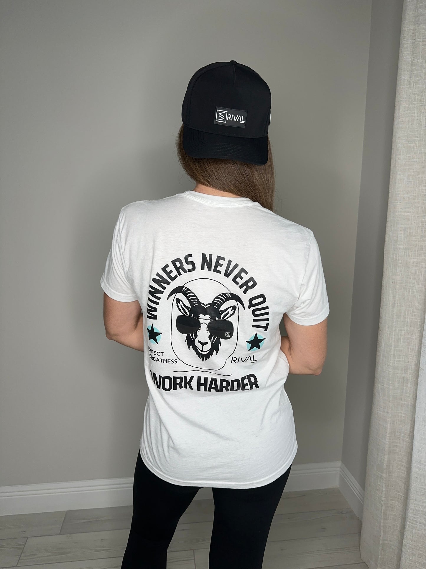 Person wearing a white t-shirt with motivational text and graphics, standing against a neutral background.