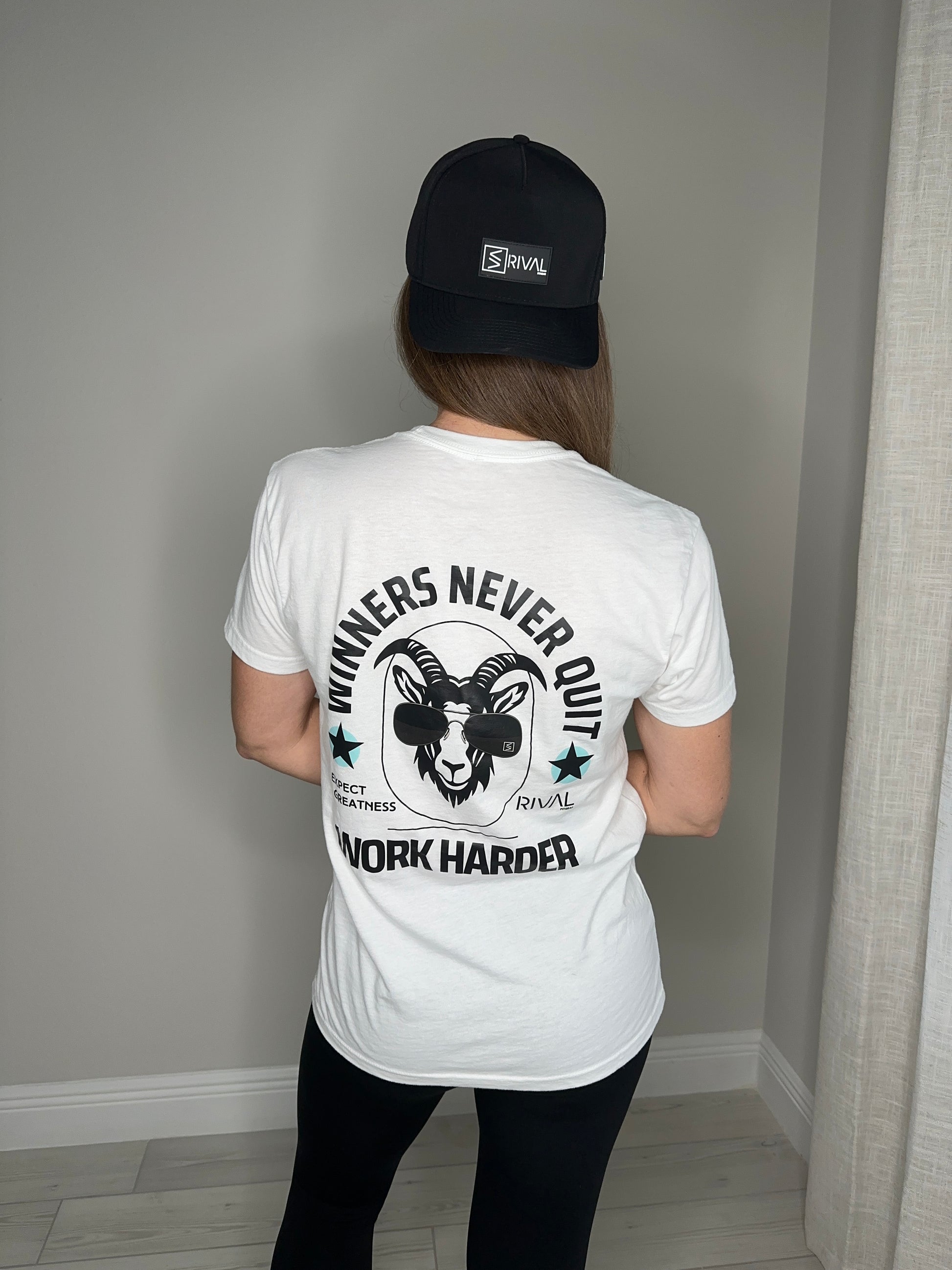 Person wearing a white t-shirt with motivational text and graphics, standing against a neutral background.